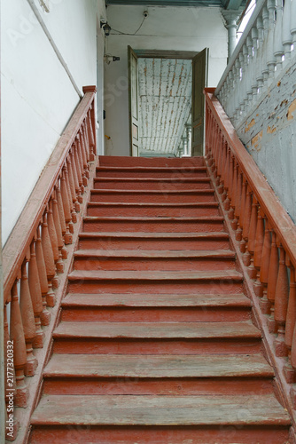 Fotografie Rustic wooden stairs with red paint and balustrade leading up