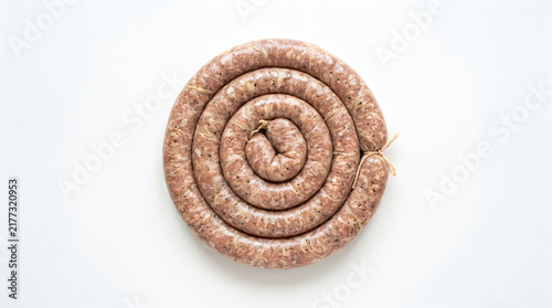 A top down view of a raw coiled pork sausage isolated on a clean white background