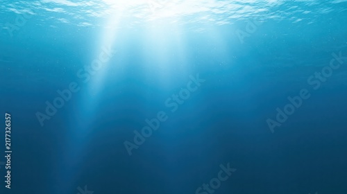 Panoramic underwater ocean background with soft sunlight rays, clear blue water and expansive open space, creating a serene marine backdrop with generous copy space.