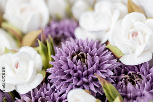 Floristry from Zephyr. Close-up of purple and white artificial flowers arranged together, showcasing intricate details of petals and leaves in a vibrant floral display
