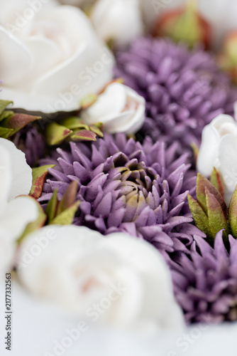 Floristry from Zephyr. Close-up of white roses and purple flowers arranged together, showcasing intricate petal details and vibrant colors in a floral composition