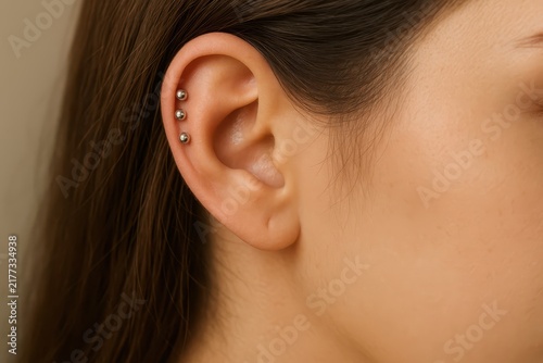 Close-up of woman's ear with triple helix piercing