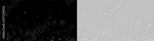 A diffuse scattering of glowing particles is dispersed against a deep black background. The particles vary in size and have a soft, ethereal quality with gentle luminosity.