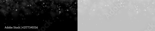 Densely scattered white bokeh spots float near the top edge of a deep black background. The bright, blurry dots vary in size and create a soft glowing effect.