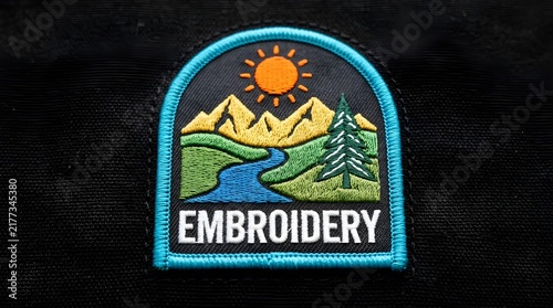 Embroidered badge patch featuring a mountain landscape with a sun river and pine tree on a dark black fabric background