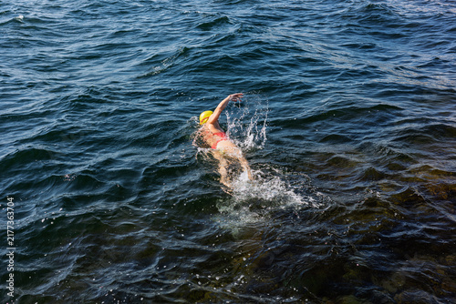 Cuadro en lienzo A woman swimming freestyle in the wavy deep blue sea of the Baltic coast on a su