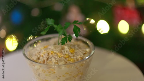 Festive Homemade Salad with Corn and Parsley Against Blurry Christmas Lights