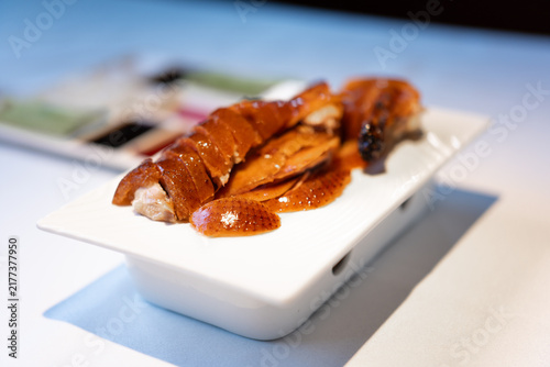 Quadro su tela Cantonese Roast Duck with Crispy Skin Served on White Plate in a Modern Restaura