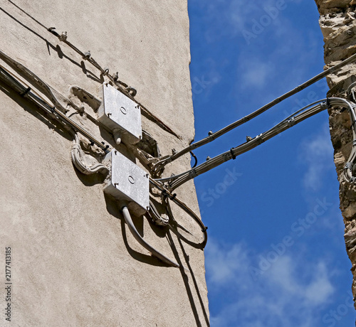 Electrical and telephone cables on a masonry wall