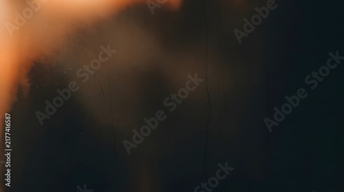 Abstract background texture featuring a beautiful vintage ember film wash effect with soft glowing orange light and dark moody shadows
