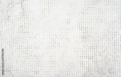 Full frame background texture of sharp bright white concrete surface with a fine dotted grid pattern
