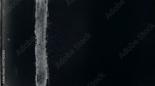 Abstract macro photography showing fine graphite dust and abrasion marks on a dark textured surface with subtle industrial grit details