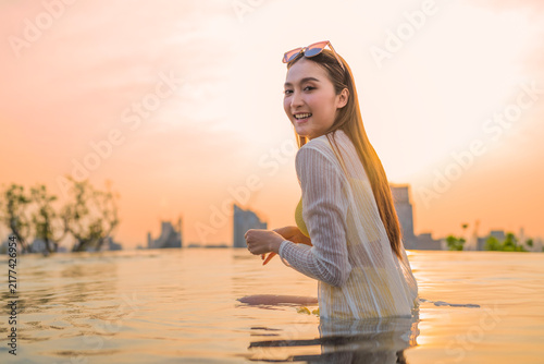 Fotografía Young cheerful woman laughing at luxury rooftop sunset, embracing pure summer freedom, joy, travel vitality, and wellness lifestyle while relaxing on scenic city holiday getaway