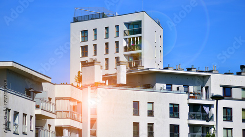 Modern apartment buildings on a sunny day with a blue sky. Facade of a modern apartment building. Glass surface with sunlight.