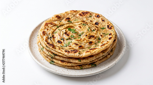 close up of stacked golden brown naan bread on minimalist white plate, puffed and charred edges, layered circular arrangement