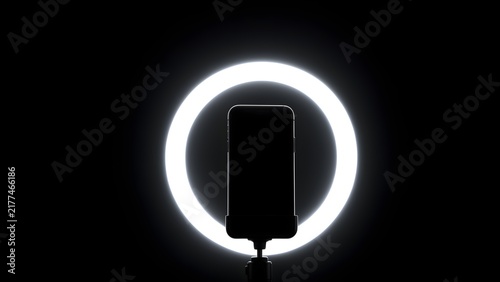 Ring light glowing in a dark room with phone mount, creator night shoot