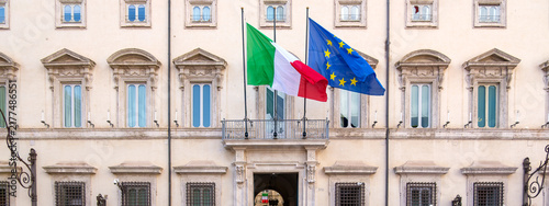 Italian and European Union flags waving above the entrance balcony of Palazzo Chigi, seat of the government in Rome Italy