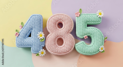 Chunky knitted numbers 485 in pastel blue, pink, and mint green with delicate floral accents.
