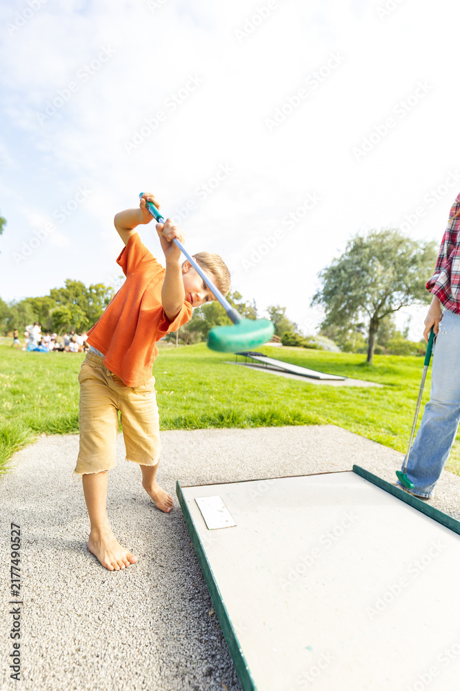 Obraz premium Child enjoying mini golf in park learning game