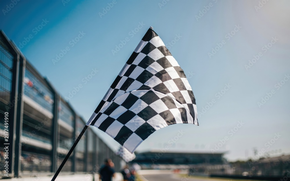 Fototapeta premium Checkered finish line flag waving at a racetrack, low angle view