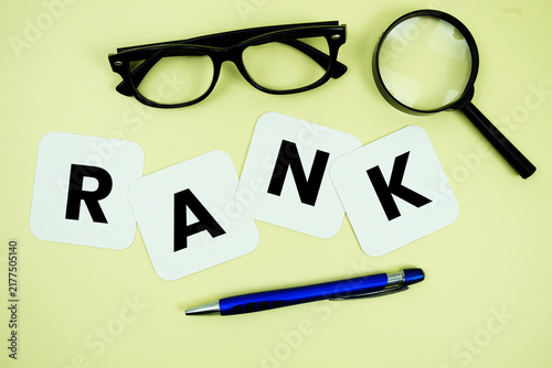 Obraz na płótnie RANK alphabet letters with magnifying glass, eye glasses and pen on yellow backg