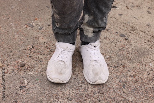 Poor man wearing old dirty sneakers outdoors, closeup