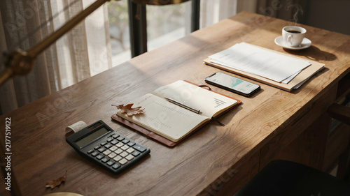 Wooden office desk with calculator notebook smartphone and coffee cup