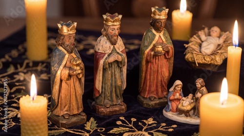 Three Kings Figurines Near Nativity Scene With Baby Jesus Figure And Candlelight For Epiphany Holiday And Día De Los Reyes Tradition