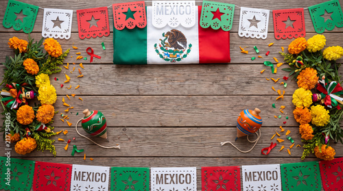 Mexican flag, papel picado, marigold flowers, spinning tops on rustic wood. Mexican culture, celebration, Day of the Dead, Independence Day, Mexico, Día de la Independencia.