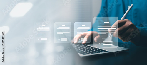 Business professional signing digital documents on a laptop with a stylus, representing electronic signatures, contract approval, document management, legal agreements, secure digital transactions.