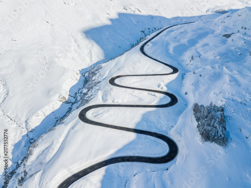 Drone view of the winding road over the Julier Pass in Swiss Alps mountain in winter, Canton Grison, Switzerland. Julier Pass is the only pass that is open through the year in Switzerland.