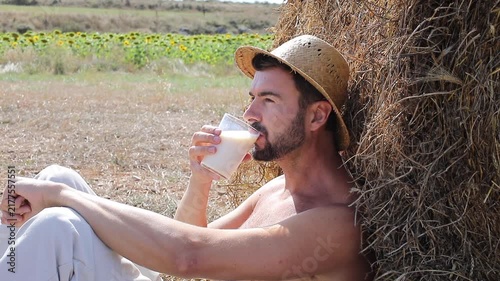 Attractive Shirtless Farmer Drinking Fresh Milk in Sunflower Field
