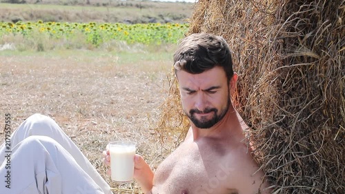 Attractive Shirtless Farmer Drinking Fresh Milk in Sunflower Field
