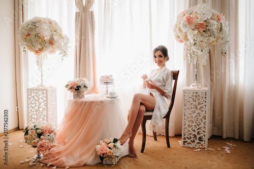 A young bride sits at a slot machine in the morning and drinks coffee