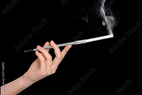 Konstfotografi Woman smoking cigarette with holder against black background, closeup