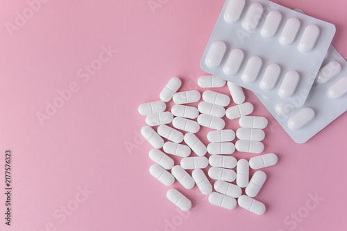 Tablets or pills in white package on the pink background with place for text.