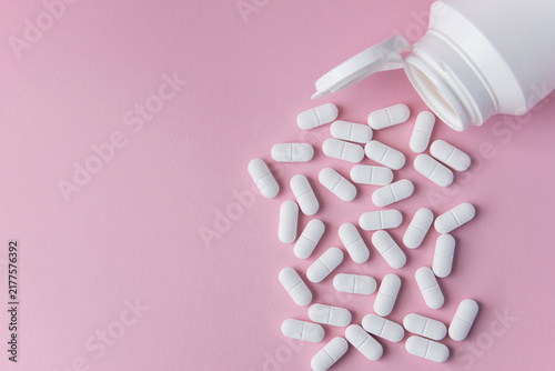 Bild auf Leinwand White tabletts or pills on the pink background with place for text