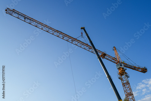 Fotografie Mobile Crane Installing Long Jib Section During Tower Crane Assembly at Construc