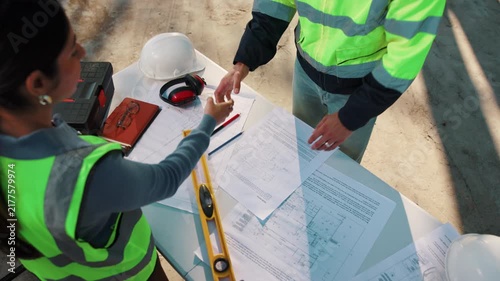Handshake, blueprint and construction team outdoor with building, repairs or renovation deal. Floor plan, people and contractor shaking hands with civil engineer for property remodeling from above.