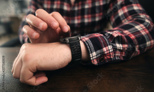 Man Scrolling On A Smartwatch Screen Checking Settings And Apps