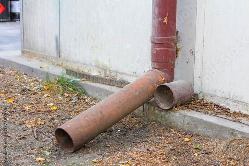 Warsaw, Poland,May 15, 2026. Close-up view of a metal gutter drain pipe near a building foundation in Warsaw. High quality photograph