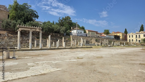 Athens, Greece - 4 July 2026. The Roman Agora contains marble columns, a restored Ionic colonnade and ancient paving, bordered by trees and buildings.