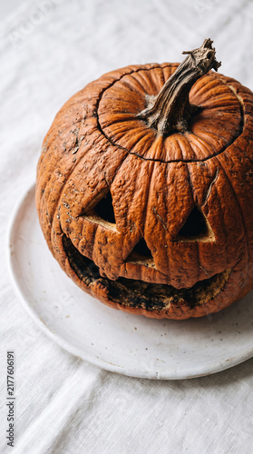 Close up of rustic carved Halloween jack o lantern pumpkin isolated on white background