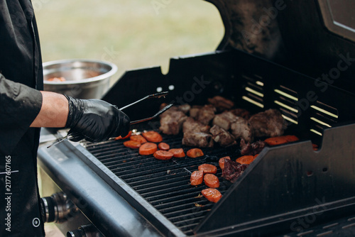 Chef grilling meat and vegetables outdoors