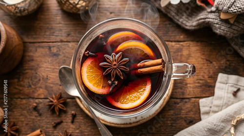 Warm mulled wine with orange slices cinnamon and star anise on a wooden table
