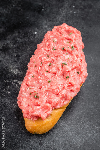 Foto Raw beef cannibal sandwich with minced beef and red onion served on bread roll o