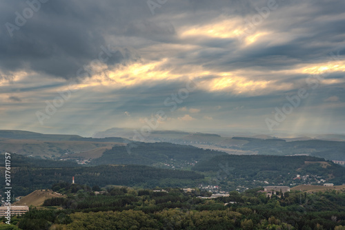 Картината върху платно A mountain range covered in the wild woods illuminated by the golden light of the setting sun
