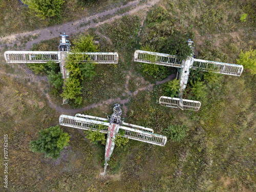 Look down on rusting AN-2 aircrafts in overgrown abandoned summer airfield