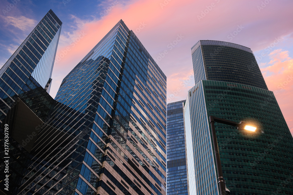 Fototapeta premium Sunse t sky displays pink and orange hues, Tall skyscrapers dominate the skyline