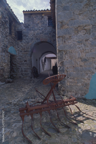 Quadro su tela an antique rusty metal cultivator or field tiller with tines and a seat, often used as a rustic garden ornament